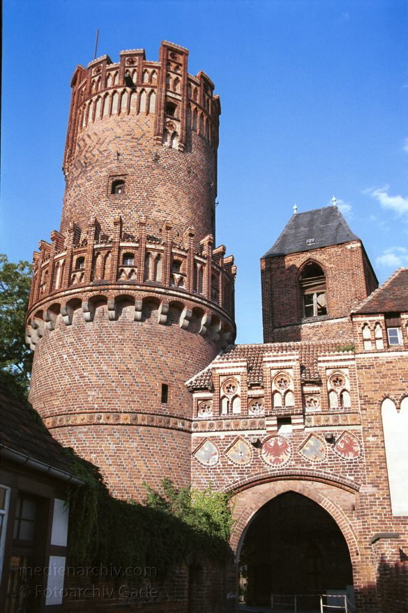 <br>Neustdter Tor. Mittelalterliche Toranlage. Der rechteckige Turm wurde um 1300 gebaut. Der Rundturm und der Mittelbau entstanden um 1450.<br>Die Putzblenden ber der Toreinfahrt tragen 1897 aufgemalte Wappen. V.l.n.r.:<br>Preuischer Knigsadler, Reichsadler des Bismarckreiches mit dem aufgelegten Hohenzollernschild, Tangermünder Adler, Adler des Heiligen Rmischen Reiches Deutscher Nationen,  Brandenburgischer Adler.